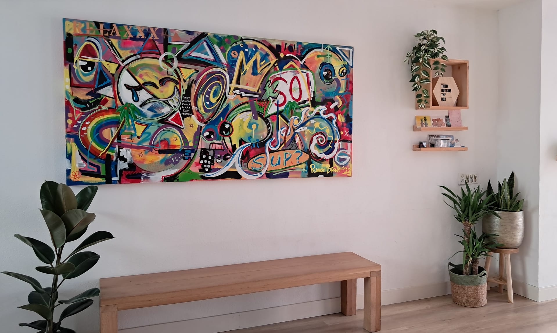 Entree met kunstwerk, houten bank en planten
